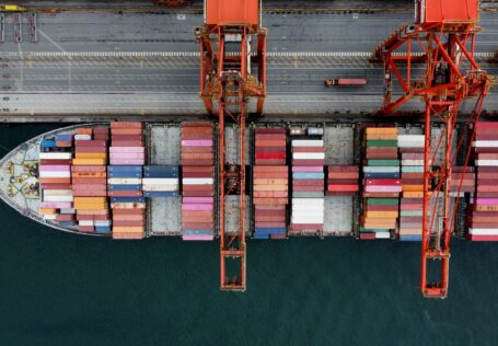 Escáner de rayos X inspeccionando contenedores de carga en un puerto marítimo para detección de contrabando